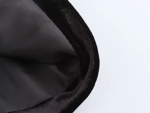 Primer plano detallado de la textura de terciopelo negro y forro interior de sarga