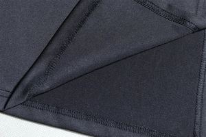 Close-up of high-quality stitching and fine knit fabric on the hem of a black evening dress