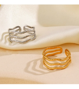 Detailed view of layered wavy stackable open rings with hand-hammered gold and silver textures