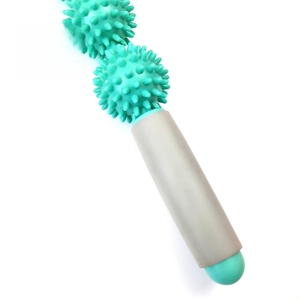 Close-up of mint green spiked massage roller balls and a gray handle for deep muscle relief