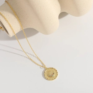 Detailed close-up of a golden starfish coin pendant with colorful zircon stones on white