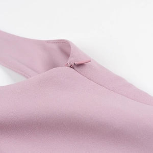 Détail de la fermeture éclair invisible sur le tissu plissé de la robe violette