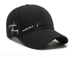 Side 45-degree view of black cotton baseball cap with white cursive letter embroidery