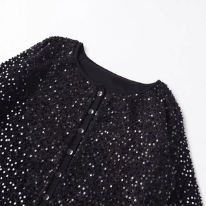 Dettaglio della giacca con paillettes nere con scollo rotondo e finitura lucida