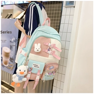 Detail of macaron colorblock schoolbag with cute plush pendants and multi-pocket design