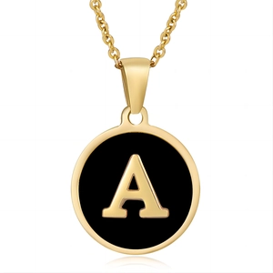 Classic gold necklace with black circular pendant featuring a golden letter A charm