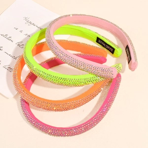 Macro detail of multi-color padded rhinestone headbands with handmade label
