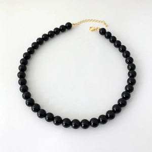 Detailed view of black onyx beaded necklace with gold lobster clasp and extension chain