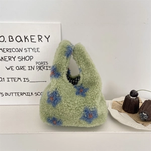 Détail du sac à main en peluche vert avec motifs floraux et doublure à carreaux