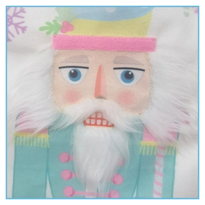 Close-up of a blue nutcracker soldier embroidery on a white fabric Christmas stocking