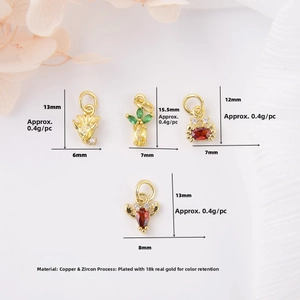 Macro detail of 18k gold plated copper crab and pineapple charms with colorful zircons