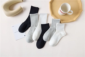 Detailed view of six pairs of cotton ribbed mid-calf socks in black, white and grey