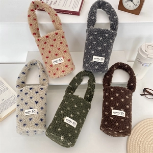 Close-up of fluffy plush beverage bags featuring heart patterns in various colors