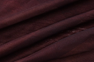 Détail de la maille tricotée bordeaux foncé montrant la texture fine et le drapé du tissu