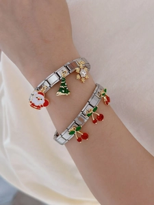 Close-up of silver Italian charm bracelet with festive Santa, tree, and cherry pendants
