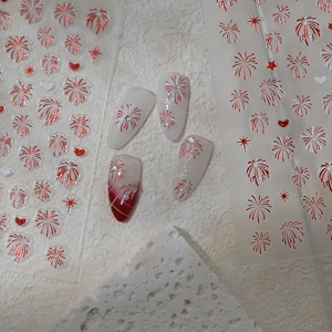Detailed macro of festive red firework nail art stickers with metallic star patterns