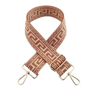 Detail of adjustable wide bag strap featuring brown and beige geometric maze patterns