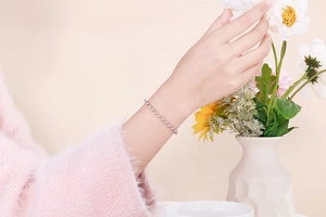 Close-up of minimalist silver beaded bracelet worn on wrist showing metallic luster