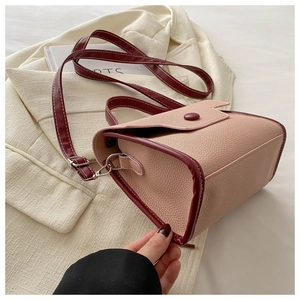 Close-up of pink and burgundy patchwork leather handbag with premium metal buckles