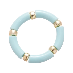 Bracciale rigido minimalista in acrilico con perle azzurre e dorate su fondo bianco