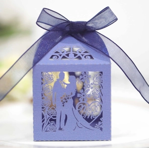 Detail of purple laser-cut wedding favor box with Mr & Mrs silhouette and ribbon bow