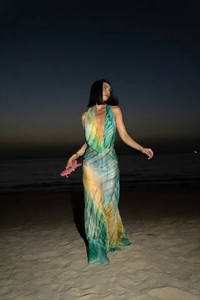 Detail of bohemian halter neck maxi dress featuring vibrant tie-dye pattern and pleated fabric