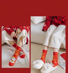 Gros plan de chaussettes de Noël douces en polaire corail rouge avec motif chat porte-bonheur