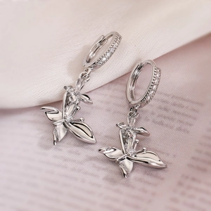 Silver butterfly drop earrings with sparkling cubic zirconia on elegant white silk