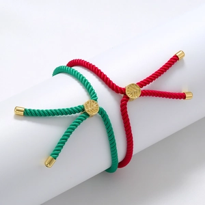 Detail of adjustable woven Tree of Life bracelets in red and green with gold metal clasps