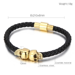 Macro detail of braided leather bracelet with golden skull charms and steel clasp