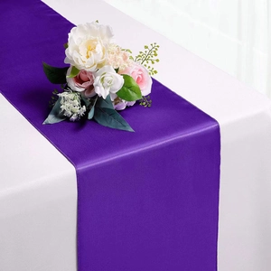 Elegant purple satin table runner displayed on white cloth for wedding banquet decoration