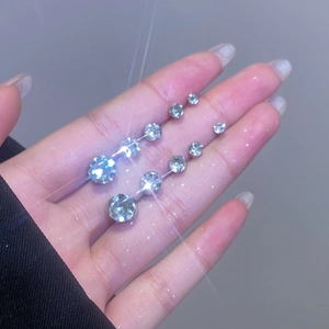 Sparkling copper zircon ear cuff set in various sizes held by hand on a purple background