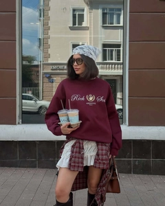 Vue street style d'un sweat-shirt rouge foncé avec broderie blanche et motif couronne