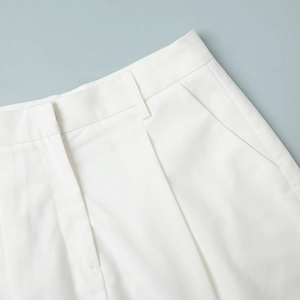 Close-up of white high-waisted shorts with side pockets and clean twill fabric texture