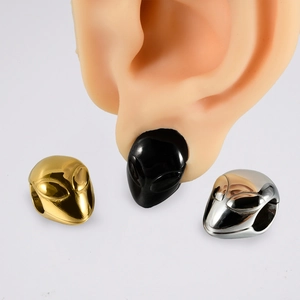 Macro shot of alien skull ear weights in gold, black, and silver stainless steel finish