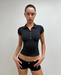 Close-up of black slim-fit short-sleeved Polo shirt with matching mini shorts on a model