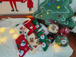Dettaglio di calze natalizie in cotone colorate con motivi festivi e confezione regalo