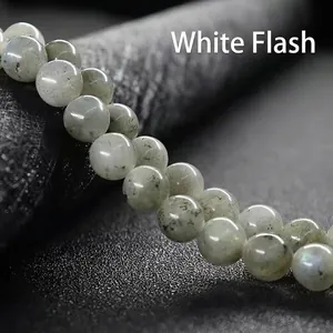 Macro shot of natural gray-green gemstones with black inclusions and white flash effect