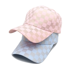 Close-up of pink and blue checkered baseball caps with shimmering glitter texture detail