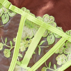Close-up of neon green lace lingerie with floral embroidery and adjustable straps