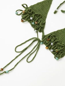 Detail of green handmade crochet bikini top with multicolor beaded accents and knit texture