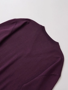 Dettaglio dello scollo a costine e delle cuciture sulla spalla del maglione in maglia viola