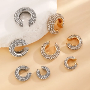 Detailed view of gold and silver C-shaped ear cuffs with sparkling pavé rhinestones