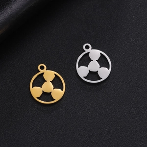 Detailed view of gold and silver cutout leaf pendants on a textured black background
