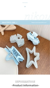 Close-up of mint blue and cream star and bow-shaped hair claws on a wooden table