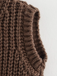 Close-up of brown chunky knit sweater vest showing texture of shoulder and neckline