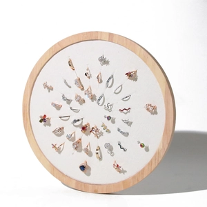 Macro display of rings set with pearls and zircons on a round wooden jewelry stand