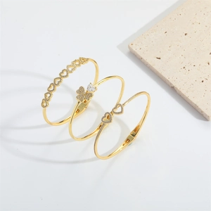 Adjustable gold clover and heart charm bangles set with sparkling zircon crystals