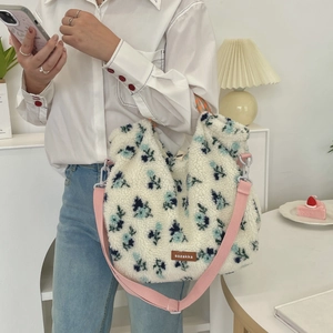 Detailed texture of floral lamb wool tote with adjustable pink strap and brand logo