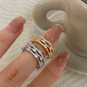 Macro view of gold and silver layered rings with branch texture and zircon inlay